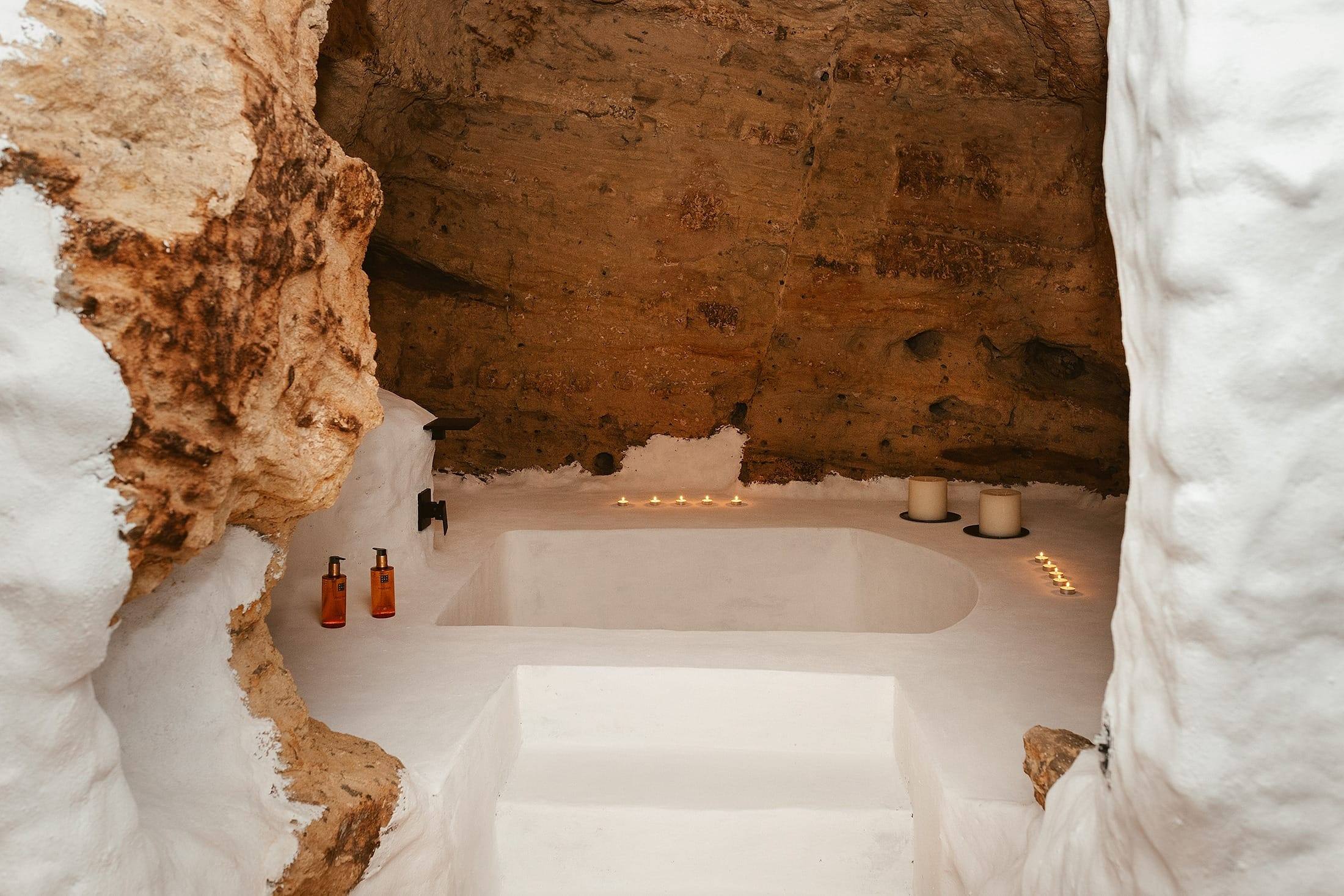 Verdolaga, excavada en la roca: la bañera en el suelo y el paso iluminado hacia la ducha