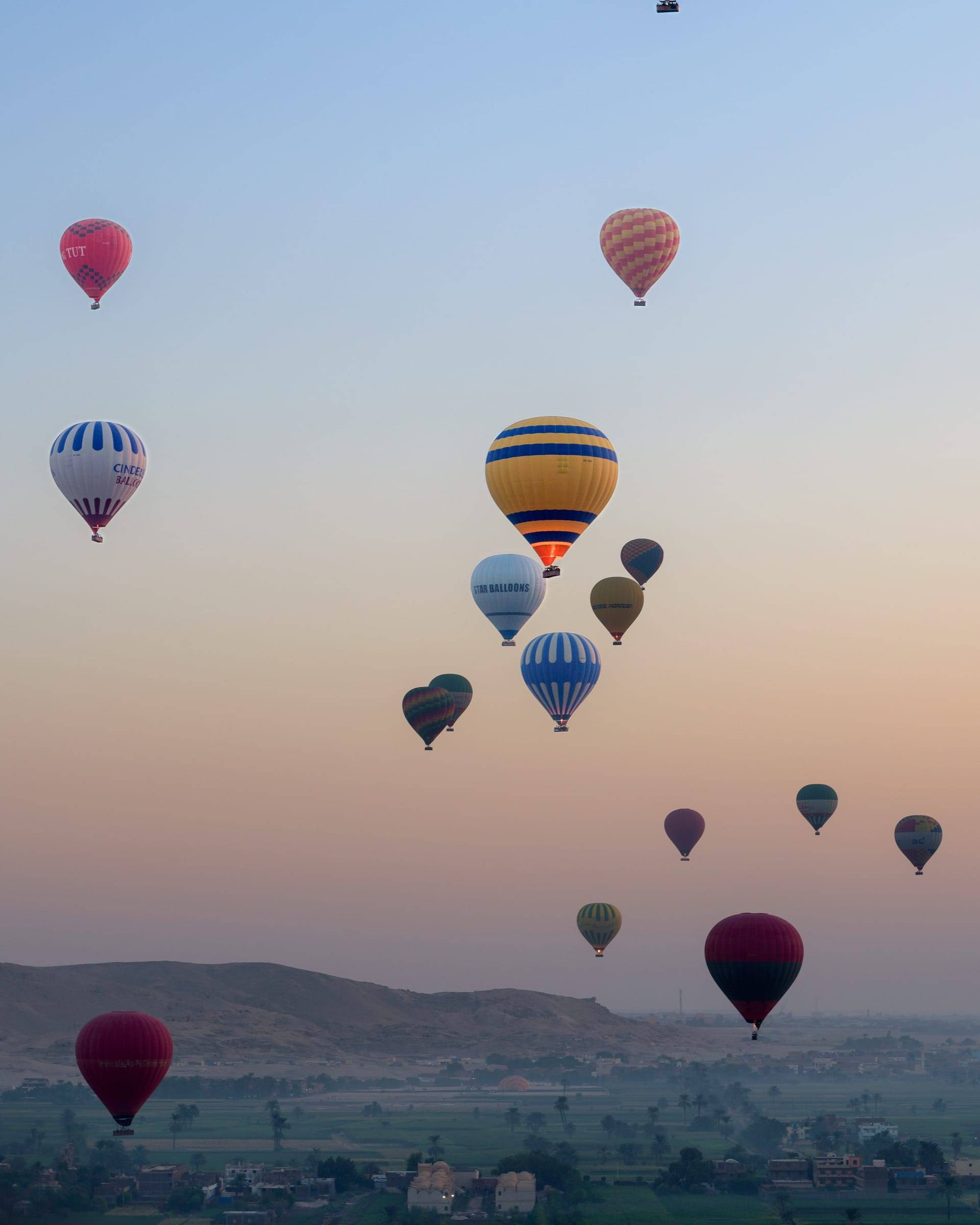 Globos aerostáticos sobre un valle al amanecer